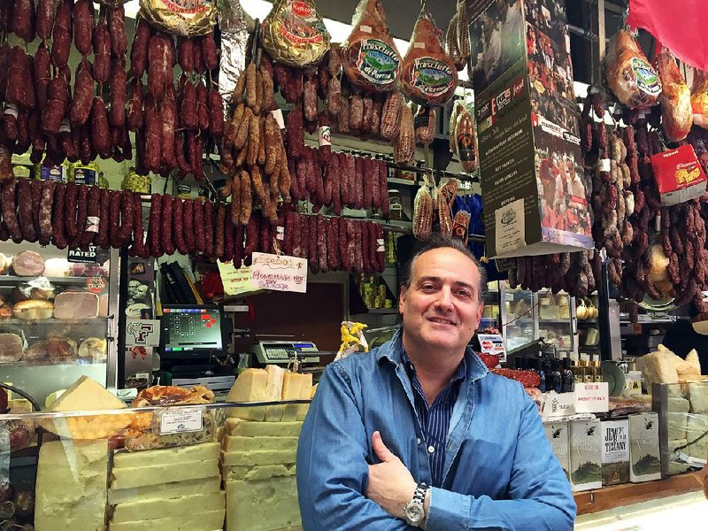 David Greco stands in front of meats and cheeses on display at Mike’s Deli in the Arthur Avenue Retail Market in the Bronx borough of New York. 