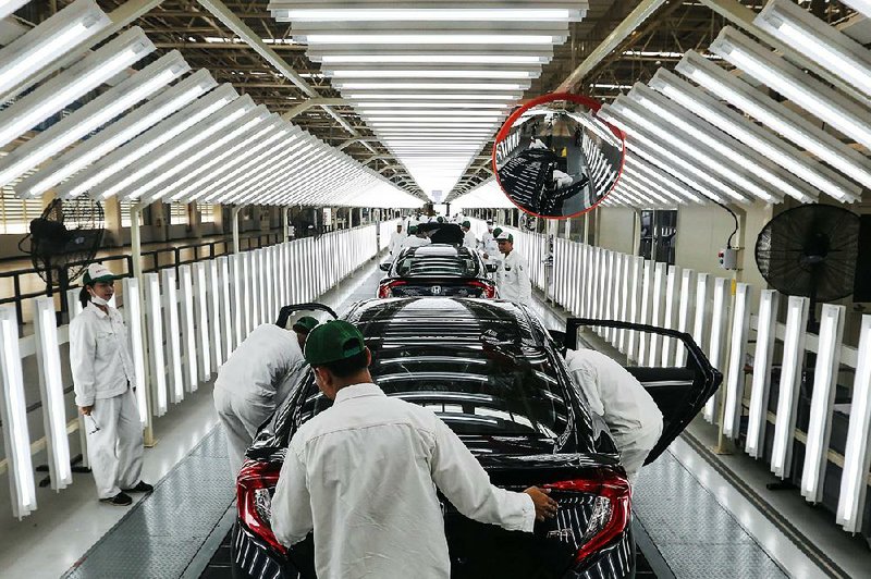 Honda workers inspect Civics near the end of an assembly line Thursday at a plant in Thailand’s Prachinburi province.