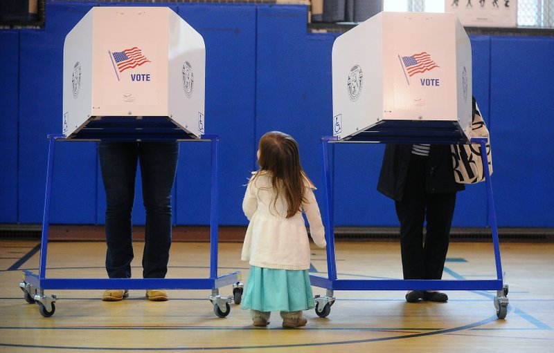 Brigit Mulligan (right) casts her vote as her daughter, Giovanna Candido, watches Tuesday during the New York primary election at the Sanford St. School in Glens Falls, N.Y.