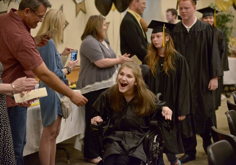 Morgan England leads the entry procession of graduates Friday during the graduation ceremony for special education students at Bentonville High School.