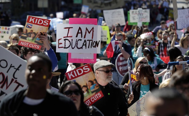 In this Feb. 23, 2013 file photo, teachers, students, parents and school administrators march up Congress Avenue to the state Capitol, in Austin, Texas to a rally for Texas public schools.  
