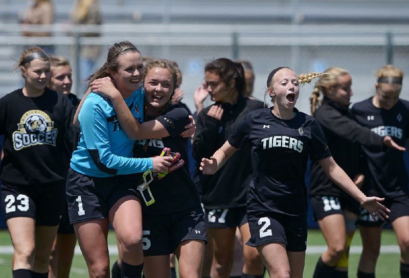 Bentonville goalkeeper Gabby Miller (left) celebrates with teammate Melanie Matkins after she stopped the final shot in penalty kicks for a 1-0 victory over Bryant on Saturday in the semifi nals of the Class 7A girls soccer tournament at Springdale.