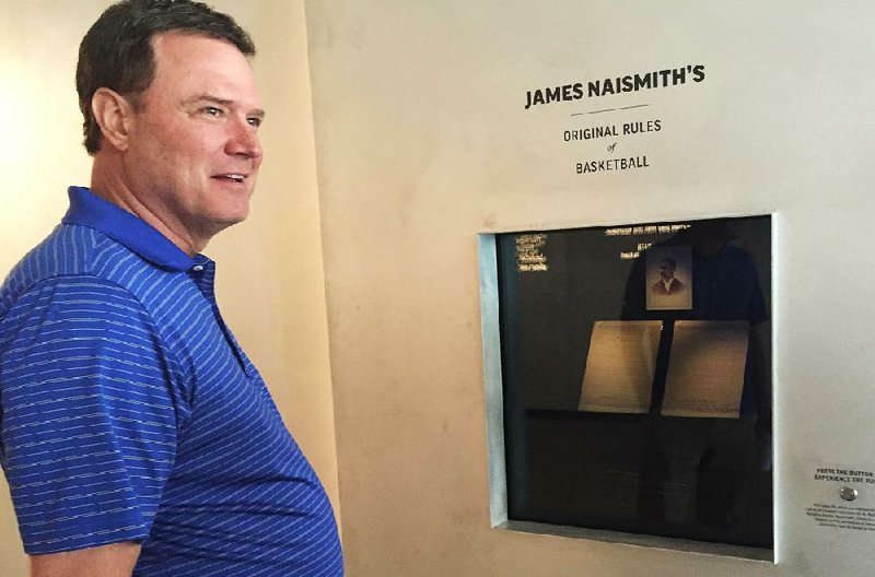 Kansas Coach Bill Self views a new display at the school of the original rules of basketball, written by James Naismith, who invented the game and coached Kansas in 1898-1907