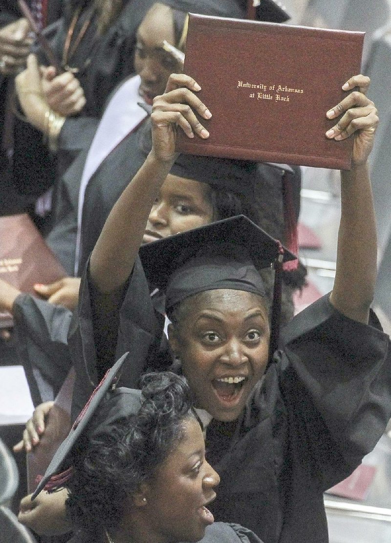 Kamesha Brooks shows off her diploma to family members attending a University of Arkansas at Little Rock graduation ceremony Saturday at the Jack Stephens Center. UALR was one of several universities in the state to hold commencement ceremonies Saturday. 