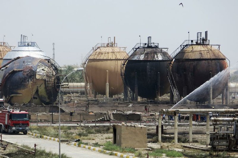 Iraqi firefighters battle a blaze at a natural gas plant in Taji, Iraq, 12 miles north of Baghdad. According to Iraqi officials, the Islamic State militant group launched a coordinated assault on the plant.
