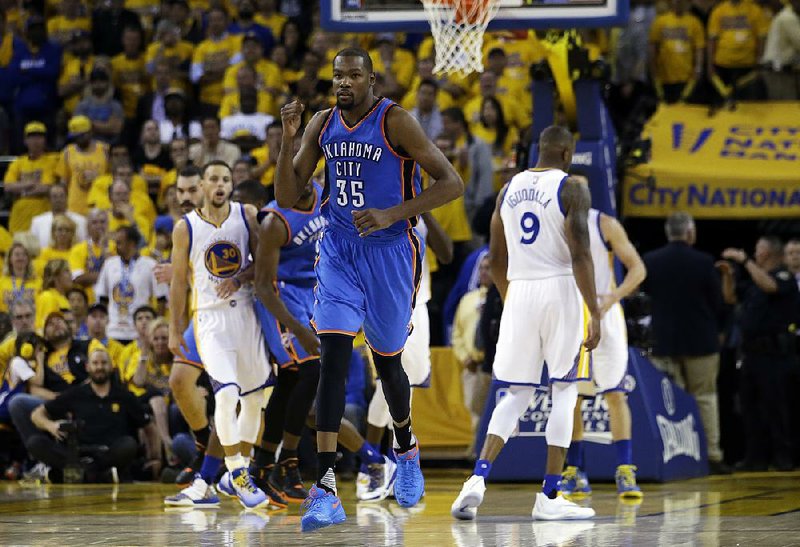 Oklahoma City forward Kevin Durant pumps his fi rst after hitting a shot late in the fourth quarter to help the Thunder beat Golden State 108-102 on Monday night in Game 1 of the NBA Western Conference final.