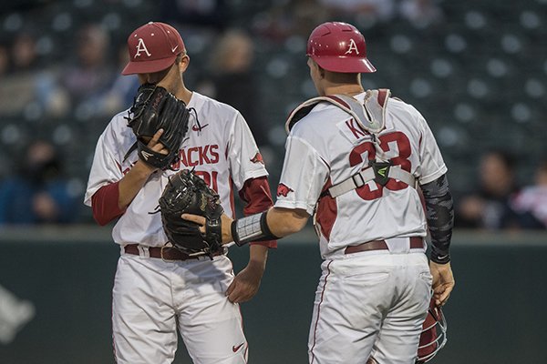 Kacey Murphy (21) talks with Grant Koch (33) both of Arkansas against Missouri State University Tuesday, May 17, 2016 at Baum Stadium in Fayetteville.