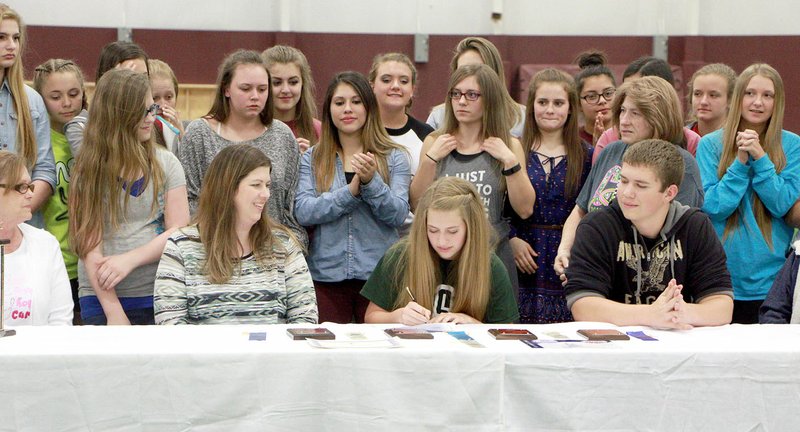 Photo by Patrick Lanford Lexie Clark (center), accompanied by family, friends, classmates and cheerleaders, signed her letter of intent to attend Northeastern State University in Tahlequah, Okla., next fall and to be a cheerleader there.
