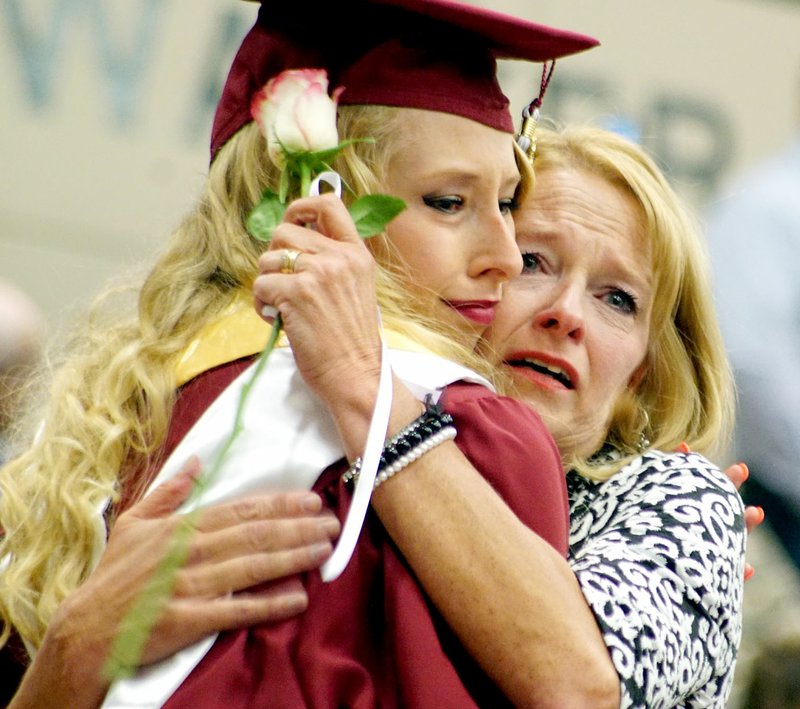 Photo by Randy Moll After presenting her a rose, Lauren Little hugs her mother, Melissa Little, at the Gentry High School graduation ceremonies held in the Bill George Arena on the campus of John Brown University on Sunday (May 15, 2016).