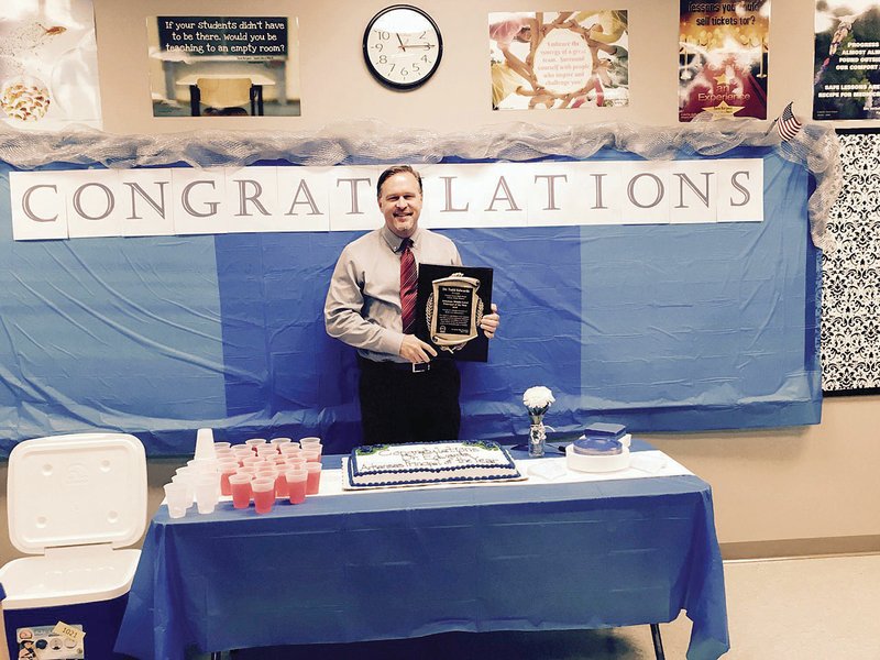 Conway Junior High School Principal Todd Edwards holds the plaque he received last week as he was named Middle Level Principal of the Year by the Arkansas Association of Educational Administrators. 
Edwards was surprised with the presentation and reception.