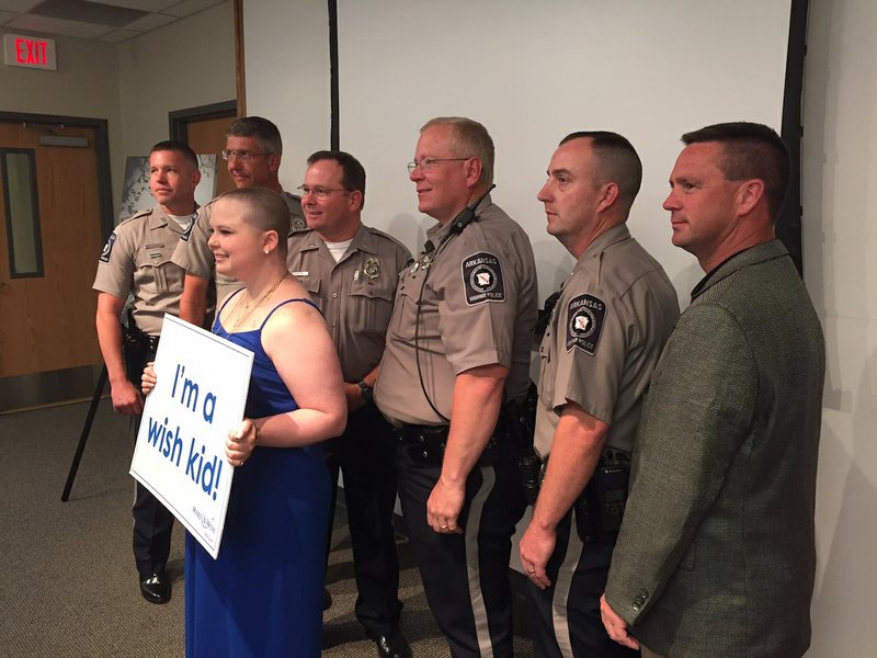 Nashville teenager Kaden Peebles, 18, is surrounded by members of Arkansas Highway Police at her Make-A-Wish reveal Wednesday, May 18, 2016. 