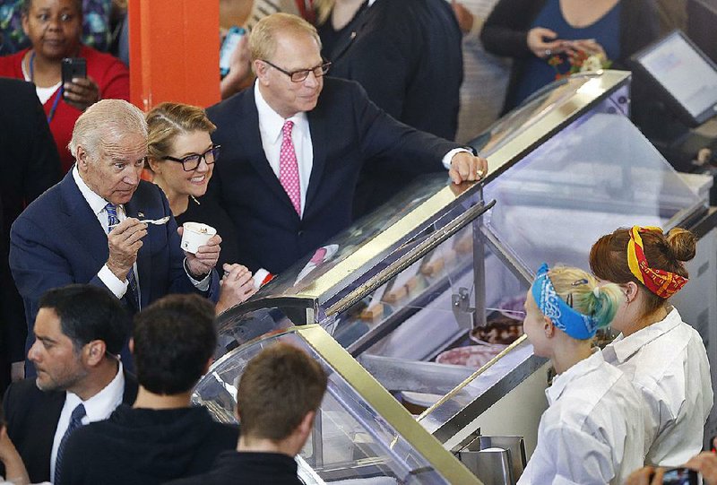 Vice President Joe Biden tries a spoonful of ice cream Wednesday with Jeni’s Splendid Ice Cream founder Jeni Britton Bauer (second from left) at her shop in Columbus, Ohio. Biden announced a new White House rule making millions of workers eligible for overtime pay during his stop at the shop. 