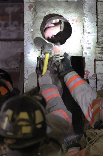 Carroll, Iowa, firefighters break apart a chimney to free a man who got stuck inside the night of May 17, 2016, apparently trying to break into Carroll Redemption Center.