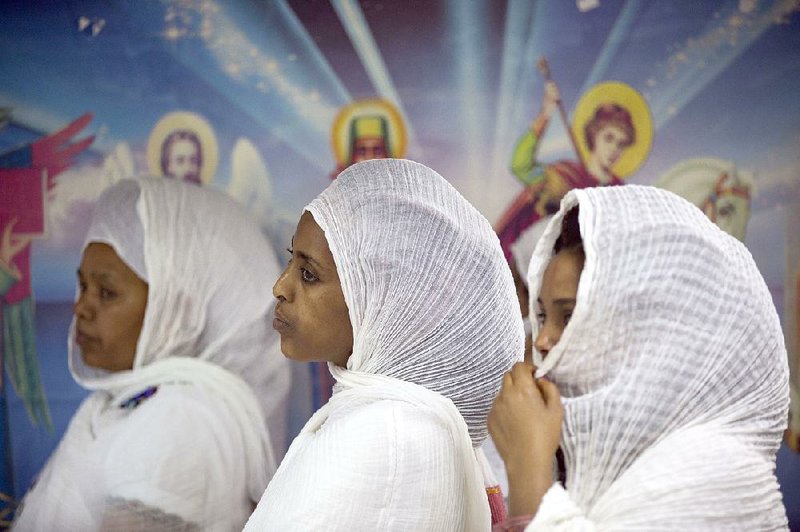 Christian Orthodox migrant women from Eritrea stand during a worship service at a makeshift church in Tel Aviv, Israel. Hundreds of the migrants gather each week to worship and pray. 