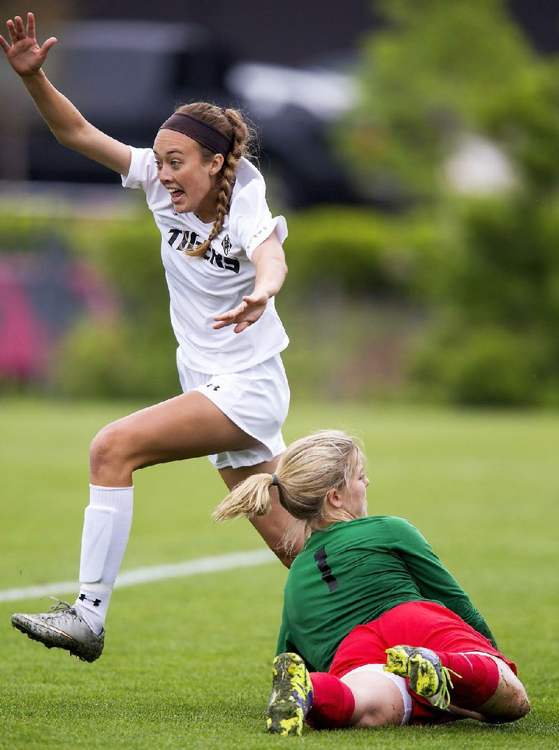 Junior Lauren Holly (left) of Bentonville celebrates after scoring past Cabot freshman goalkeeper Maggie Martin in the Class 7A girls soccer championship game Friday at Razorback Field in Fayetteville. Bentonville won its fourth girls title in five years.