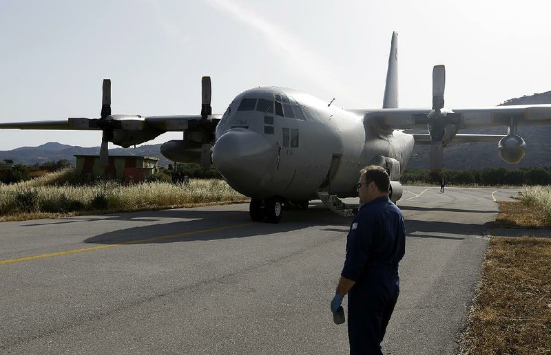 An engineer stands in front of a C-130 HAUP of the Hellenic Air Force, which took part and is on stand by, in the searching operation of the missing Egypt plane, at the military air base of Kastelli on the southern Greek island of Crete on Friday. 