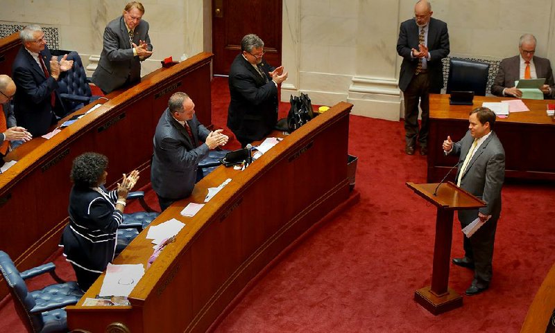 Sen. Jon Woods, R-Springdale (right), gives a thumbs up to colleagues during a standing ovation after Woods’ bill, dubbed the Frank Broyles Publicity Rights Protection Act of 2016, passed on the Senate floor on Friday. 