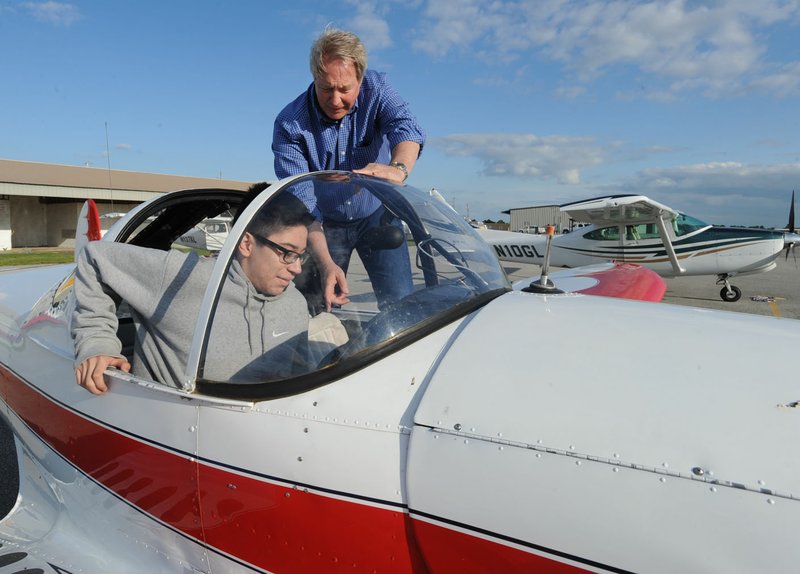 Pilot Tim Keaten (right) helps student Fernando Lopez, 14, into an airplane before taking flight Wednesday during the Wright Flight Fly Day at the Bentonville Municipal Airport. Pilots with the Tailwind Aviation Foundation flew with six students from Crossroads, Rogers’ alternative high school.