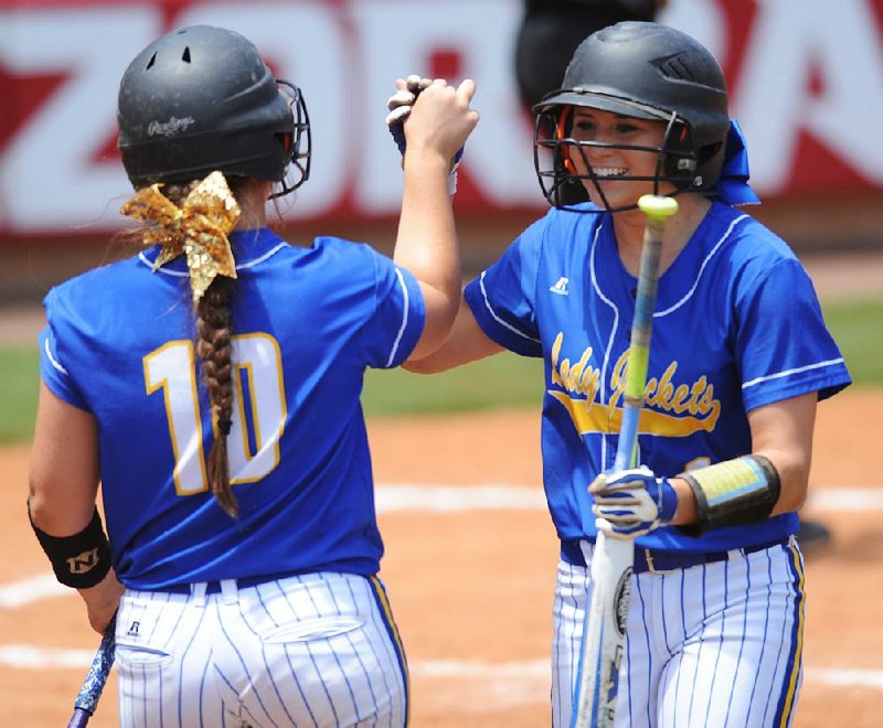 Baserunner Maggie Hicks (right) is greeted by Corbin Talbert after scoring a run for Sheridan in Saturday’s Class 6A state softball final at Bogle Park in Fayetteville. The Lady Yellowjackets beat Benton 6-0 to win the title after losing in the championship game the past two seasons. 