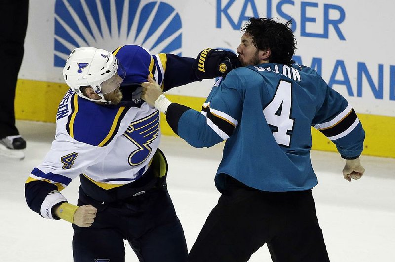 Carl Gunnarsson of the St. Louis Blues (left) fights with Brenden Dillon (4) of the San Jose Sharks during the third period of the Blues’ 6-3 victory over the San Jose Sharks on Saturday night. The series is tied 2-2 with Game 5 Monday night in St. Louis.