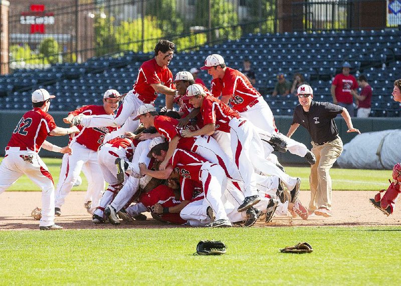 Magnolia players pile on the infield after beating Sylvan Hills 4-1 to win the Class 5A state championship Saturday at Baum Stadium in Fayetteville.