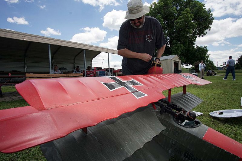 Gary Crawford of Paragould fuels up a radio-controlled Red Baron model airplane during the Warbirds Over Arkansas event Saturday in North Little Rock. 