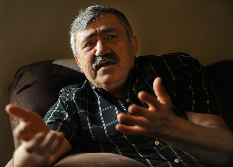 Faez Shamas Arso speaks May 12 in his home in Fayetteville. Arso fled Iraq with his wife and daughter to escape persecution by ISIS, leaving behind his job as an electrical engineer for the state rail company.