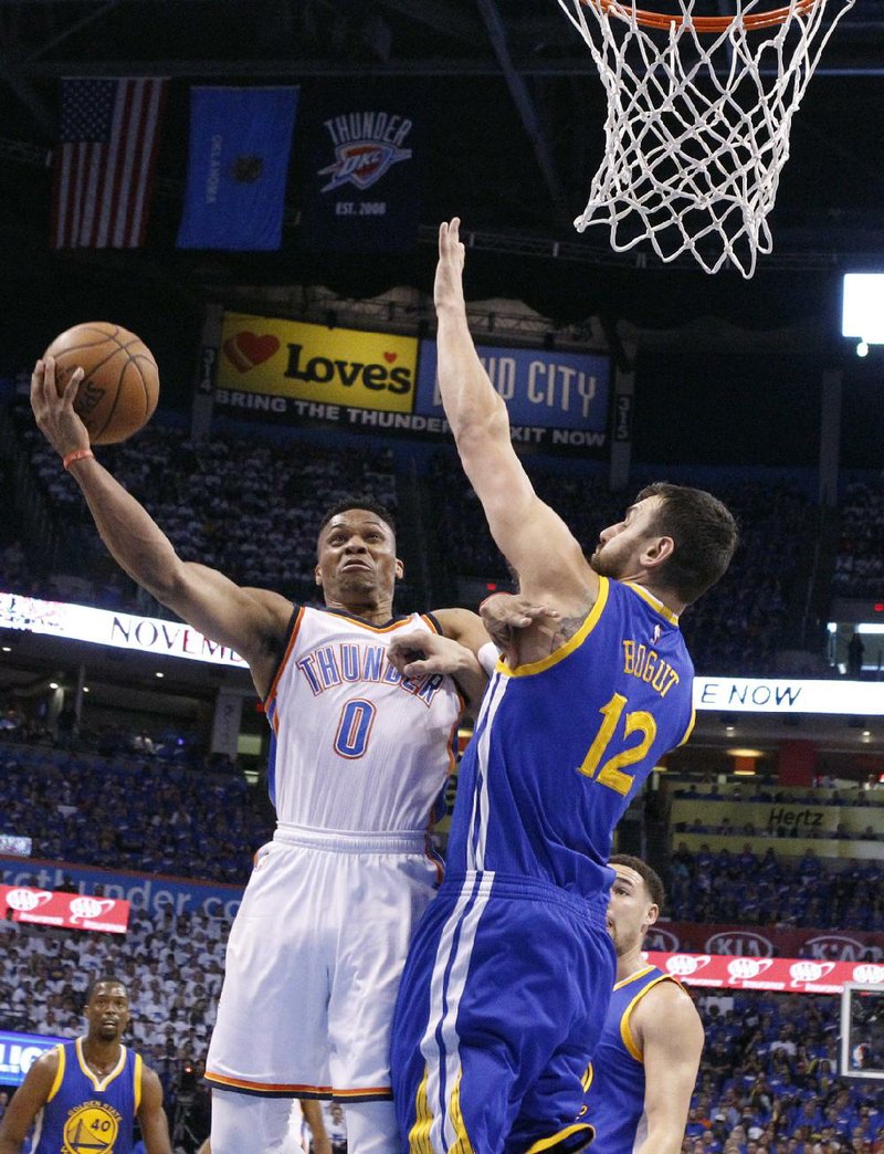 Oklahoma City guard Russell Westbrook (left) shoots as Golden State center Andrew Bogut defends during the first half of Sunday’s game. Westbrook finished with 30 points, 8 rebounds and 12 assists as the Thunder handed the Warriors a 133-105 defeat and grabbed a 2-1 lead in the NBA Western Conference final.
