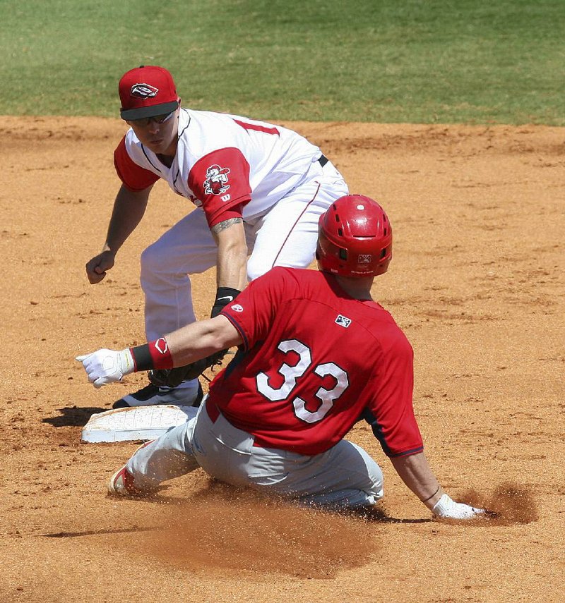 Arkansas second baseman Alex Yarbrough (left) tags out Springfield’s Harrison Bader during Sunday’s game at Dickey-Stephens Park in North Little Rock. The Travelers beat the Cardinals to win for the fifth time in their past six games.