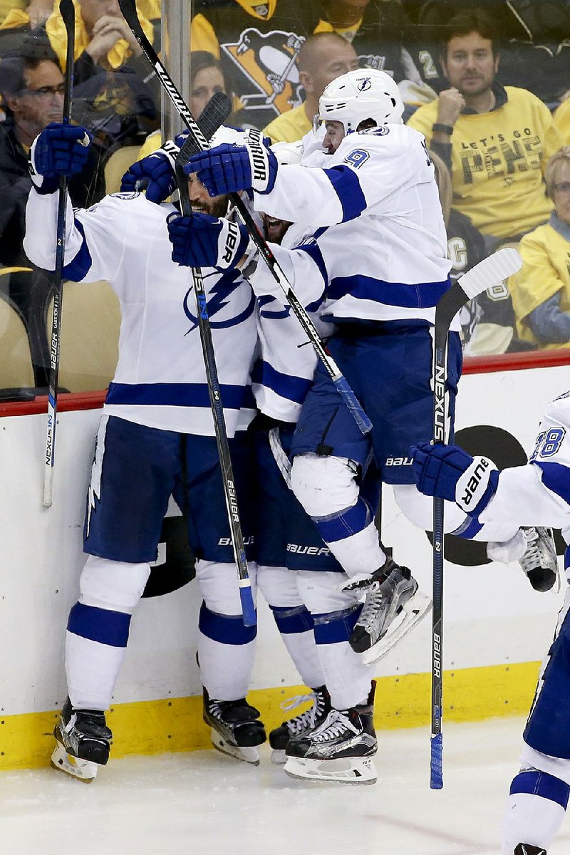 Tampa Bay players celebrate after Tyler Johnson (right) scored the game-winning goal in overtime to beat Pittsburgh 4-3 in the NHL Eastern Conference fi nal Sunday.