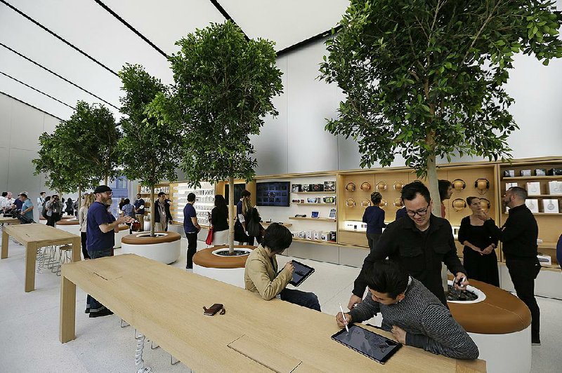 People try products in the “Genius Grove” during a preview of the new Apple Union Square store last week in San Francisco.