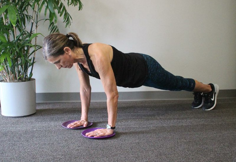 Marie Kolstad does step 1 of the Slide Disc Scissors exercise 