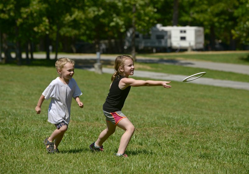 Ian Smith, 4, and Jaicee Page, 6, both of Rogers, play Sunday while camping with friends at Prairie Creek Park on Beaver Lake near Rogers.