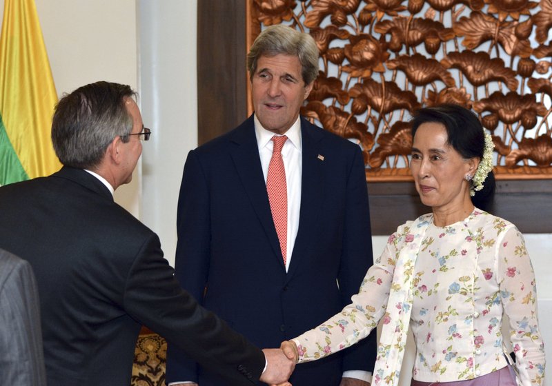 U.S. Secretary of State John Kerry, center, watches Myanmar's Foreign Minister and de facto leader Aung San Suu Kyi, right, and U.S. Ambassador to Myanmar Scot Marciel shake hands during a meeting in Naypyitaw, Myanmar, Sunday, May 22, 2016. 