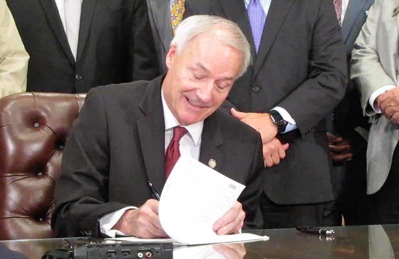 Gov. Asa Hutchinson on Monday, May 23, 2016, signs a highway funding bill into law at the state Capitol in Little Rock. 