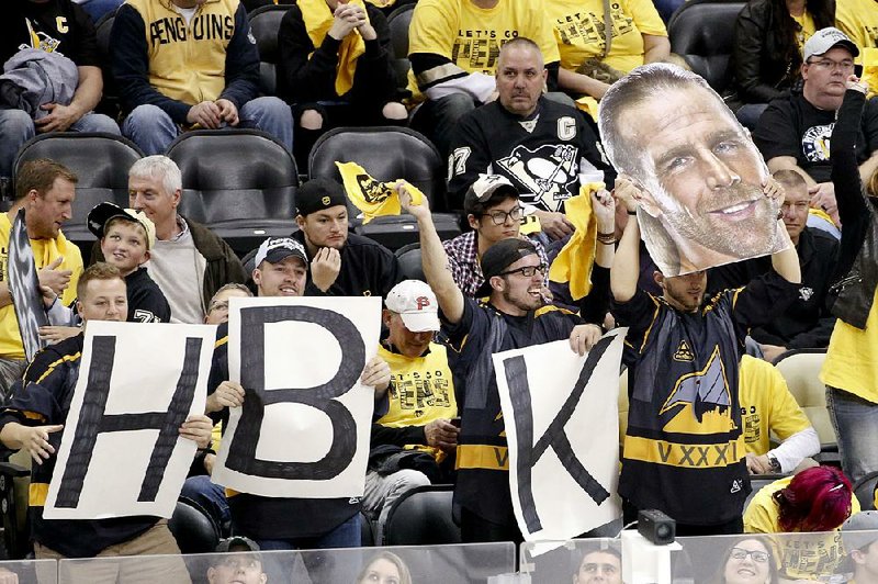 Fans hold up a poster of former World Wrestling Entertainment star Shawn Michaels and posters of H-B-K letters during Game 5 of the NHL Eastern Conference final Sunday in Pittsburgh. The Pittsburgh Penguins’ third line is
known as the HBK line, in honor of Michaels’ nickname, the Heartbreak Kid.