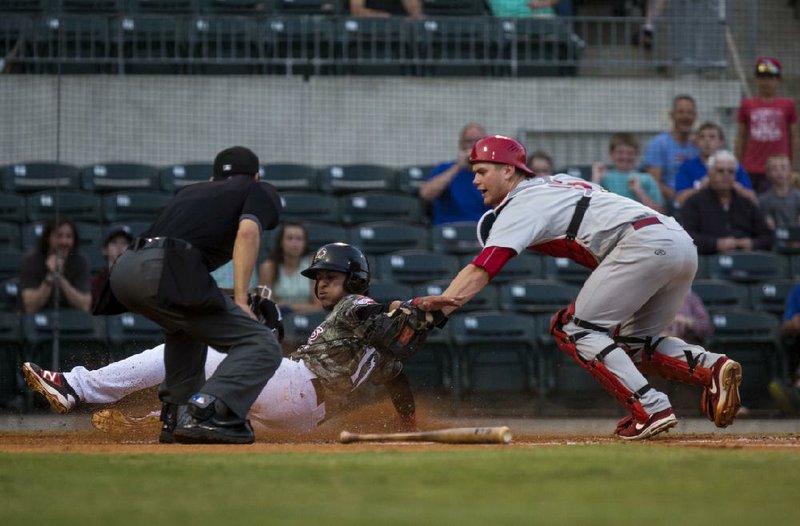 Arkansas Travelers baserunner Jose Briceno (left) is tagged out at home plate by Springfield catcher Carson Kelly during Monday night’s game at Dickey-Stephens Park in North Little Rock. The Cardinals jumped out to an early five-run lead and held on to beat the Travelers 8-3.