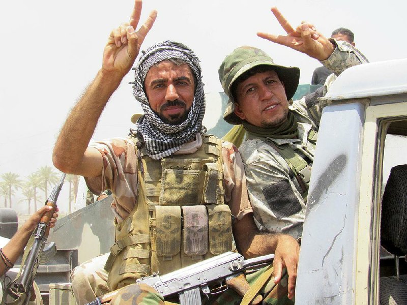 Shiite militia fighters give the victory sign Monday outside Fallujah, Iraq, after the start of an operation to recapture the city from the Islamic State. Government forces reported regaining parts of the city’s northeastern edge.