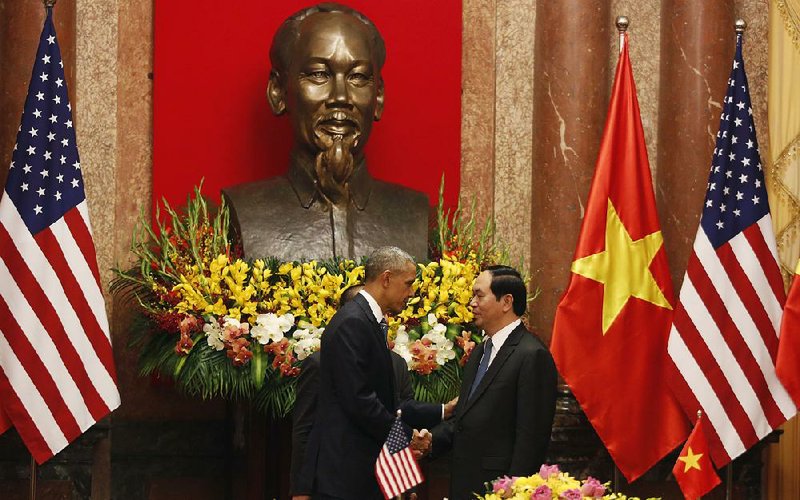 President Barack Obama shakes hands Monday with Vietnamese leader Tran Dai Quang under a statue of Vietnamese revolutionary leader Ho Chi Minh at the Presidential Palace in Hanoi, Vietnam.