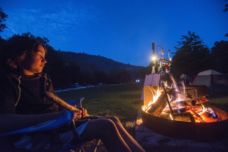 Cruz Reyes, 11, of Springdale basks in the fire’s glow while camping with his family May 6-8 at Kyle’s Landing along the Buffalo National River.