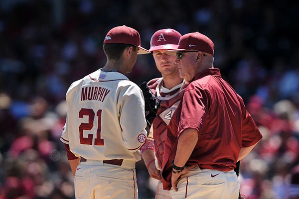 Arkansas pitching coach Dave Jorn, right, talks with catcher Tucker Pennell, center, and pitcher Kacey Murphy during a game against Texas A&M on Sunday, May 1, 2016, at Baum Stadium in Fayetteville. 