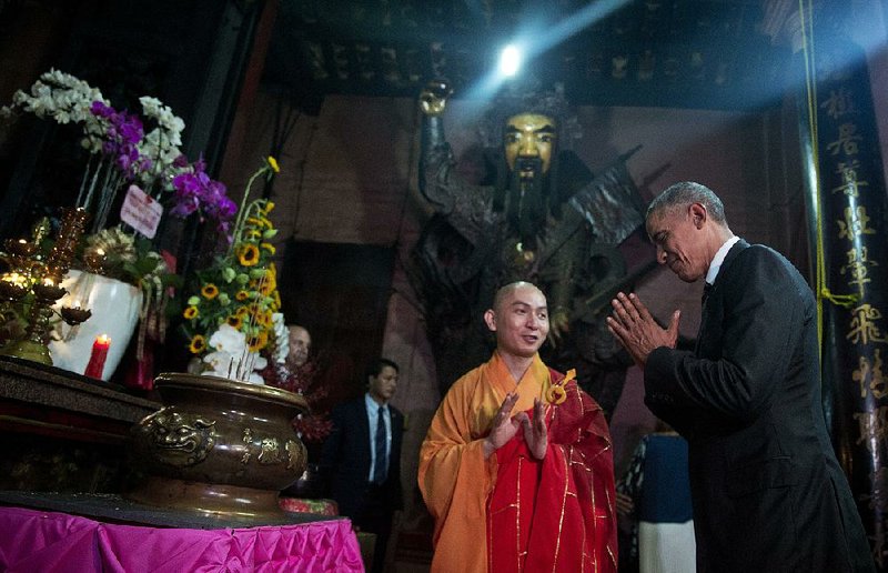 President Barack Obama bows as he visits the Jade Emperor Pagoda with Thich Minh Thong, abbot of the pagoda, in Ho Chi Minh City, Vietnam, on Tuesday. The Jade Emperor Pagoda is one of the most notable and most visited cultural destinations in Ho Chi Minh City. 