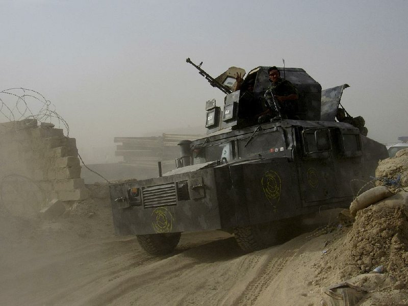 An Iraqi federal police vehicle arrives Tuesday at a government position outside Fallujah, about 40 miles west of Baghdad. 