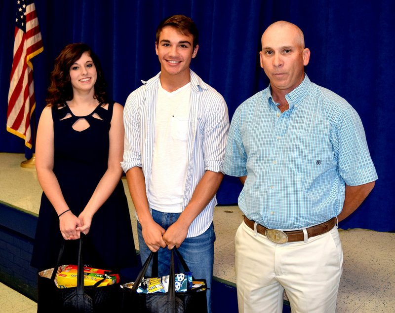 Photo by Mike Eckels Haley Burden (left), valedictorian, and Tyler Riddle, salutatorian, accept bags of gifts from Justin Lovitt, chamber president, during the Honors Banquet May 9 in the cafeteria of Decatur High School. The Decatur Chamber of Commerce, with the help of the Decatur School District, hosted the event to honor the top graduates in the class of 2016.