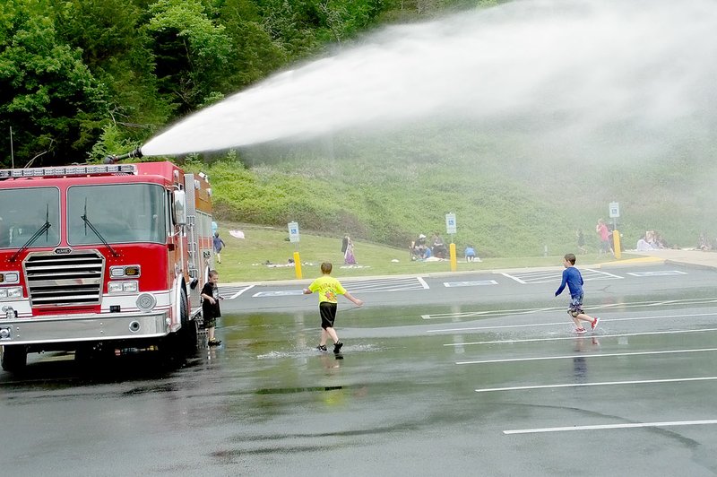 Lynn Atkins/The Weekly Vista Although it was only 68 degrees, Cooper first graders played in the spray from a Bella Vista fire truck during their annual Field Day last week.