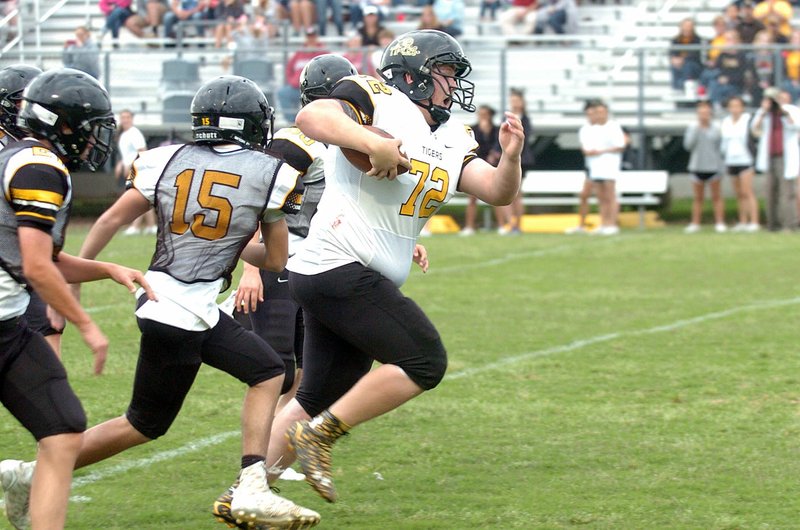 MIKE CAPSHAW ENTERPRISE-LEADER Prairie Grove&#8217;s Will Hawkins bullied his way through several defenders on his way to the end zone after catching a pass on a tackle-eligible play that was called by a fan during the Tigers&#8217; spring scrimmage on May 20.