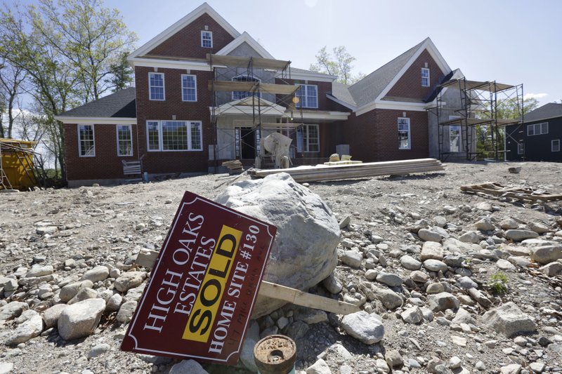 In this Wednesday, May 18, 2016, photo, a "Sold" sign rests in front of a house under construction, in Walpole, Mass. 