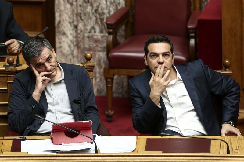 Greece's Prime Minister Alexis Tsipras, right, and Finance Minister Euclid Tsakalotos, attend a parliamentary session in Athens, Sunday, May 22, 2016.