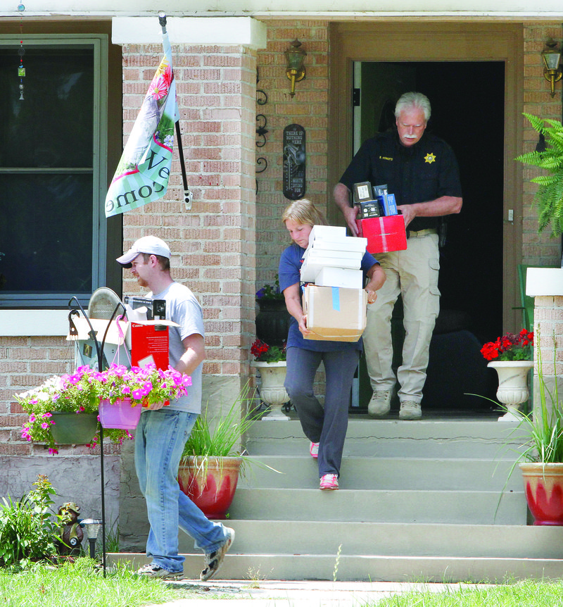 Union County Sheriff-elect Ricky Roberts, rear, assists others with the retrieval of Randy Duck’s possessions from the home of his ex-wife, Renee Pitard. 