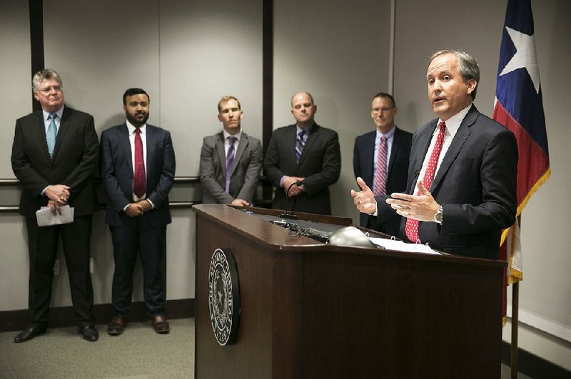 Texas Attorney General Ken Paxton (right) on Wednesday announces a lawsuit that claims a federal directive on transgender students’ restroom use is “running roughshod over commonsense policies protecting children and basic privacy rights.” 
